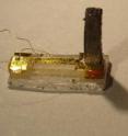 This torque cantilever is used to measure magnetic property of bismuth in intense magnetic fields. The bismuth crystal (5.6 mm tall vertical pillar) is glued to the end of a thin cantilever beam made of gold. Deflections of the cantilever in a field are detected by measuring changes in capacitance.