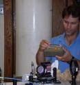 University of Utah physicist Brian Saam examines tubes of invisible xenon gas that he used to explore the relationship between chaos theory and modern quantum physics.