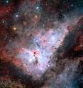 Color-composite image of the Carina Nebula, revealing exquisite details in the stars and dust of the region. Several well known astronomical objects can be seen in this wide field image: to the bottom left of the image is one of the most impressive binary stars in the Universe, Eta Carinae, with the famous Keyhole Nebula just adjacent to the star. The collection of very bright, young stars above and to the right of Eta Carinae is the open star cluster Trumpler 14. A second open star cluster, Collinder 228 is also seen in the image, just below Eta Carinae. North is up and East is to the left. The field of view is 0.55 x 0.55 degrees, covering a 144 x 144 light-year region at the distance of the nebula. Color-composite image of the Carina Nebula, revealing exquisite details in the stars and dust of the region. Several well known astronomical objects can be seen in this wide field image: to the bottom left of the image is one of the most impressive binary stars in the Universe, Eta Carinae, with the famous Keyhole Nebula just adjacent to the star. The collection of very bright, young stars above and to the right of Eta Carinae is the open star cluster Trumpler 14. A second open star cluster, Collinder 228 is also seen in the image, just below Eta Carinae. North is up and East is to the left. The field of view is 0.55 x 0.55 degrees, covering a 144 x 144 light-year region at the distance of the nebula.