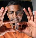 Purdue professor Joseph Irudayaraj uses a magnet to attract tiny magnetic particles in a solution. Irudayaraj designed nanoprobes with gold and magnetic particles that could be used to deliver drugs directly to cancer cells.
