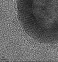 Partial view of a gold nanosphere (shown), magnified by a factor of one billion, as seen through an electron microscope. The darker ring shows the "wall" of the nanosphere, while the lighter area to the right of the ring shows the interior region of the shell. Partial view of a gold nanosphere (shown), magnified by a factor of one billion, as seen through an electron microscope. The darker ring shows the "wall" of the nanosphere, while the lighter area to the right of the ring shows the interior region of the shell.