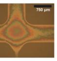 Left: Schematic of a T-junction nanofluidic device with a "nanoglassblown" funnel-shaped entrance to a nanochannel. The funnel tapers down to 150 micrometers (about the diameter of a human hair) at the nanochannel entrance.
Right: Photomicrograph of the T-junction with the first section of the nanochannel visible at the bottom. The colors are a white light interference pattern caused by the changing depth of the curved glass funnel.
