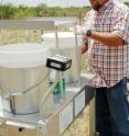 Jack Bush, a research associate with Texas AgriLife Research in Amarillo, collects a week’s worth of rainfall from an automatic precipitation collector. The rainfall sample will be sent to a laboratory at the University of Illinois for chemical analysis.