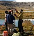 The research team in Peru at the Quelccaya Ice Cap prepares a sediment core sampler for use.