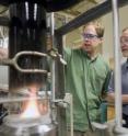Timothy B. Onasch, principal scientist for Aerodyne Research, Inc. (Billerica, Mass.) and Boston College chemistry professor Paul Davidovits check an apparatus they designed to produce uniform soot particles used for aerosols research.