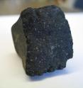 Pale specks on the surface of this meteorite are among the oldest minerals in the solar system. An odd mix of oxygen atoms within these minerals has puzzled scientists for decades.