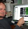University of Oregon biologist Bruce Bowerman points to images showing cell division.