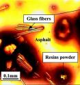 Materials from printed circuit boards used in electronics, such as computers and cell phones, could be used to strengthen asphalt paving, scientists report. Above is a micrograph of the modified asphalt.