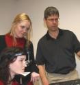Queen's University Pharmacology and Toxicology professor James Reynolds,demonstrates his group's eye-movement test to identify and assess children with fetal alcohol spectrum disorder with Neuroscience master's students Rebecca Titman (standing) and Loriann Williams (seated).