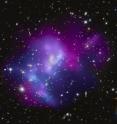 This composite image shows the massive galaxy cluster MACSJ0717.5+3745 (MACSJ0717, for short), where four separate galaxy clusters have been involved in a collision, the first time such a phenomenon has been documented.  Hot gas is shown in an image from NASA's Chandra X-ray Observatory and galaxies are shown in an optical image from NASA's Hubble Space Telescope.  The hot gas is color-coded to show temperature, similar to a temperature map of the Earth given in a weather forecast. In MACSJ0717 the coolest gas is shown as reddish purple, the hottest gas is blue and the temperatures in between are purple.

The repeated collisions in MACSJ0717 are caused by a 13-million-light-year-long stream of galaxies, gas, and dark matter -- known as a filament -- pouring into a region already full of matter. A collision between gas in two or more clusters causes the hot gas to slow down. However, the galaxies, which are mainly empty space, do not slow down as much and so they move ahead of the gas. Therefore, the speed and direction of each cluster's motion -- perpendicular to the line of sight -- can be estimated by studying the offset between the average position of the galaxies and the peak in the hot gas.
