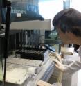 A research associate inspects robotic equipment during the DNA labeling process.