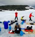 Antarctic expeditioners stretch after unloading their gear at Ace Lake and mark their arrival at their destination.