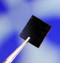A graphene material sample that was tested for its properties is shown against an image in a test station.