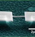 This photo shows scanning electron micrographs showing one of the doubly-clamped beam NEMS devices used in these experiments. It is embedded in a nanofabricated three-terminal UHF bridge circuit.