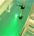 Scattered light from a 532 nm laser pulse can be seen as it enters the water in the Salt Water Tank Facility, and ionizes a small volume of water for acoustic generation.  Air bubblers and controlled water and air temperatures can create ocean-like conditions in the laboratory.