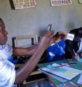 A Kenyan health worker uses a Google-powered phone to scan the barcode on a patient's new identification badge. This will identify the patient and associate his or her demographic data, and pull up the correct record when this patient travels to a clinic or hospital. A Kenyan health worker uses a Google-powered phone to scan the barcode on a patient's new identification badge. This will identify the patient and associate his or her demographic data, and pull up the correct record when this patient travels to a clinic or hospital.