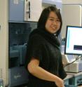 Sarah Ng, a University of Washington (UW)  graduate student in genome sciences, stands in front of a sequencer in the UW Northwest Genome Center. Ng is the lead author on a Nov. 13 <i>Nature Genetics</i> study of exome sequencing to quickly identify causative genes in single-gene disorders.