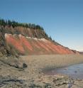 Massive lava flow (top brown layer) sits atop end-Triassic (white) and Triassic (red) layers at a site in Five Islands Provincial Park, Nova Scotia.