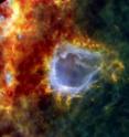 RCW 120 is a galactic bubble with a large surprise. How large? At least 8 times the mass of the sun. Nestled in the shell around this large bubble is an embryonic star that looks set to turn into one of the brightest stars in the galaxy.

The Galactic bubble is known as RCW 120. It lies about 4,300 light-years away and has been formed by a star at its center. The star is not visible at these infrared wavelengths but pushes on the surrounding dust and gas with nothing more than the power of its starlight. In the 2.5 million years the star has existed. It has raised the density of matter in the bubble wall so much that the quantity trapped there can now collapse to form new stars.

The bright knot to the right of the base of the bubble is an unexpectedly large, embryonic star, triggered into formation by the power of the central star. Herschel's observations have shown that it already contains between 8-10 times the mass of our sun. The star can only get bigger because it is surrounded by a cloud containing an additional 2,000 solar masses.

Not all of that will fall onto the star, even the largest stars in the galaxy do not exceed 150 solar masses. But the question of what stops the matter falling onto the star is a puzzle for modern astronomers. According to theory, stars should stop forming at about 8 solar masses. At that mass they should become so hot that they shine powerfully at ultraviolet wavelengths.

This light should push the surrounding matter away, much as the central star did to form this bubble. But clearly sometimes this mass limit is exceeded otherwise there would be no giant stars in the galaxy. So astronomers would like to know how some stars can seem to defy physics and grow so large. Is this newly discovered stellar embryo destined to grow into a stellar monster? At the moment, nobody knows but further analysis of this Herschel image could give us invaluable clues.