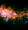 This image is taken looking towards a region of the galaxy in the Eagle constellation, closer to the galactic center than our sun. Here, we see the outstanding end-products of the stellar assembly line. At the center and the left of the image, the two massive star-forming regions G29.9 and W43 are clearly visible. These mini-starbursts are forming, as we speak, hundreds and hundreds of stars of all sizes: from those similar to our sun, to monsters several tens of times heavier than our sun.

These newborn large stars are catastrophically disrupting their original gas embryos by kicking away their surroundings and excavating giant cavities in the galaxy. This is clearly visible in the "fluffy chimney" below W43.