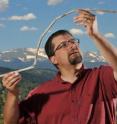 University of Colorado at Boulder Research Associate Craig Lee holds a 10,000-year-old atlatl dart that had been frozen in an ice sheet near Yellowstone National Park. The dart was straight when it was entombed and became bowed from the melting and barely survived being snapped in half by a passing animal.