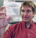Michael Riehle, holding genetically altered mosquitoes, and his team work in a highly secure lab environment to prevent genetically altered mosquitoes from escaping.