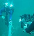 Videographer Marty O'Farrell captures divers taking a core sample from the bottom of pool 6.