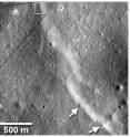 Another fault cut across and deformed several small diameter (~40-m diameter) impact craters (arrows) on the flanks of Mandel’shtam crater (6.5°N, 161°E). The fault carried near-surface crustal materials up and over the craters, burying parts of their floors and rims. About half of the rim and floor of a 20 m-in-diameter crater shown in the box has been lost. Since small craters only have a limited lifetime before they are destroyed by newer impacts, their deformation by the fault shows the fault to be relatively young.