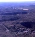 This is an aerial view of diamond mining at Kimberley, South Africa. The hole remaining after removal of kimberlite is shown in right foreground while waste dumps from which samples in this study were collected are in the center of the picture.