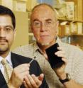 Associate professor Muhannad Bakir (left), from Georgia Tech's School of Electrical and Computer Engineering, holds a prototype electronic microplate, while Professor John McDonald, from the School of Biology, holds an example of the conventional microplate it will replace.