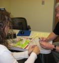 UW Medical Center patient Gene Pugnetti, 56, of Yakima, Wash. examines a new vestibular device with audiologist Elyse Jameyson.