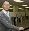 Ph.D. candidate Muer Yang, standing in front of a bank of voting machines, hopes his College of Business research will minimize the time voters stand in line to vote and equalize the time voters wait regardless of which precinct they vote in.