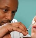A health-care practitioner administers an intranasal vaccine.