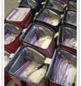 These are transport coolers containing materials for parents, including fresh diapers, plastic bags and tagging materials. Freezer blocks were laid on top.