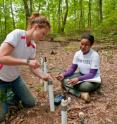 Graduate student Elizabeth Herndon (geosciences) collects a soil pore fluid sample from the Shale Hills Critical Zone Observatory while Danielle Andrews (crop and soils science) prepares to measure the pH of the water.