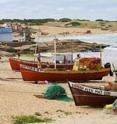 Fishing boats line the beach at Punta del Diablo, a seaside fishing community in Uruguay.