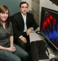 Princeton researchers, Christodoulos Floudas and Meghan Bellows-Peterson, have developed a way to use mathematical models to take some of the guesswork out of discovering new drugs. Using the technique, they have identified several potential new drugs for fighting HIV. The image on the screen shows a graphic of their drug candidate (red) attached to HIV (blue).