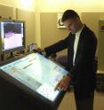 An instructor uses a prototype touch kiosk to move and align 3-D modeled assets with the Site Security Planning Tool.
