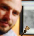 Georgia Tech Research Institute researcher Jason Nadler holds a sample of thin silver-diamond composite material. The material is being developed to help cool electronic devices.