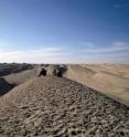 Researchers sit atop a wind-formed ridge called a yardang located in the Qaidam Basin of Central Asia. The yardangs in that area can be as much as 40 meters (about 130 feet) tall and about a football field (100 meters) apart.