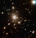 The giant cluster of elliptical galaxies in the centre of this image contains so much dark matter mass that its gravity bends light. This means that for very distant galaxies in the background, the cluster’s gravitational field acts as a sort of magnifying glass, bending and concentrating the distant object’s light towards Hubble. These gravitational lenses are one tool astronomers can use to extend Hubble’s vision beyond what it would normally be capable of observing.

Using Abell 383, a team of astronomers have identified and studied a galaxy so far away we see it as it was less than a billion years after the Big Bang. Viewing this galaxy through the gravitational lens meant that the scientists were able to discern many intriguing features that would otherwise have remained hidden, including that its stars were unexpectedly old for a galaxy this close in time to the beginning of the Universe. This has profound implications for our understanding of how and when the first galaxies formed, and how the diffuse fog of neutral hydrogen that filled the early Universe was cleared.