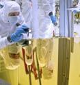 An engineer examines the Webb telescope primary mirror Engineering Design Unit segment in the clean room at NASA's Goddard Space Flight Center, Greenbelt, Md.