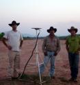 Ben Brooks, 'O. Ozcacha and Todd Ericksen stand next to one of the GPS stations that was used in the study.