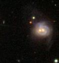 Viewed in visible light, Markarian 739 resembles a smiling face, with a pair of bright cores underscored by an arcing spiral arm. The object is really a pair of merging galaxies. Data from Swift and Chandra reveal the eastern core (left) to be a previously unknown AGN; past studies already had identified an AGN in the western core. The two supermassive black holes are separated by about 11,000 light-years. The galaxy is 425 million light-years away.