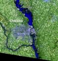 The Landsat 5 image is an enlargement of the area just north of Omaha. The flood waters show up as very dark blue and, where the water is shallow, medium blue. In the image, the Interstate is cut off by flood waters, just south of Missouri Valley, Iowa, and about 20 miles north of Omaha.