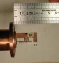 This photo shows the sample holder, made of copper, which was used in the experiment. The small gray crystal of TbMnO3 that was studied, is in the center, between two electrodes to apply an electric field.