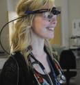 A trainee surgeon conducts a simulated operation, wearing the eye-tracking device.