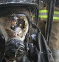 Opening the door provided additional air to a smoldering living-room fire and caused the fire to increase in burning rate and flames to extend out the doorway, resulting in high temperatures and heat flows that melted a hole in the mask. Pressure sensor (brass fitting that was mounted on the face of the headform) is visible through the hole in the lens.