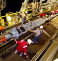 JOIDES Resolution crew members prep a CORK for installation beneath the seafloor.