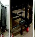 This shows a rack unit. (Left) The front view of the rack structure is fully stacked with trays in tilted position. (Center) This shows the detail of the endless screw jack system and its hand wheel controller. (Right) The back view shows the bottom frame of the rack with the plastic curtain, the metallic slide and the basket collector.